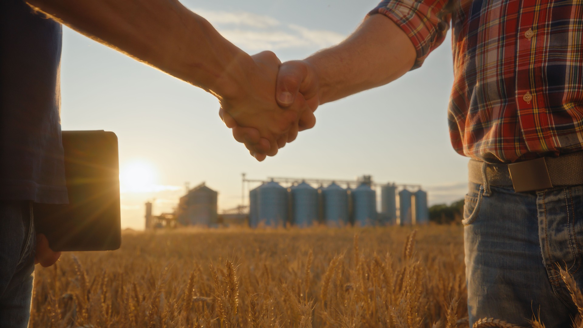 Caucasian Farmers Handshake in Wheat Field Silo Background